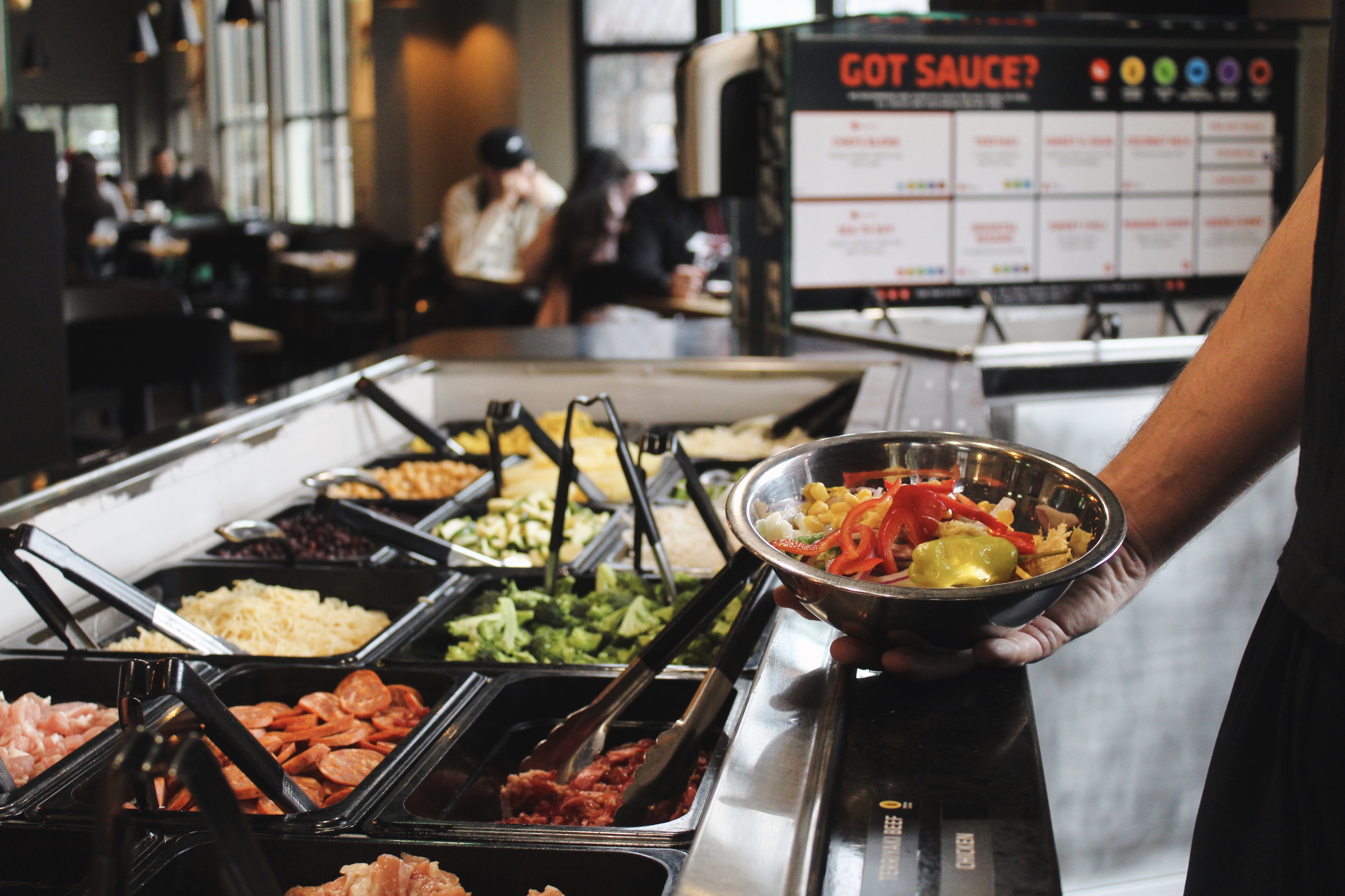 Ingredient bar with filled bowl and Got Sauce sign at Mongolie Grill