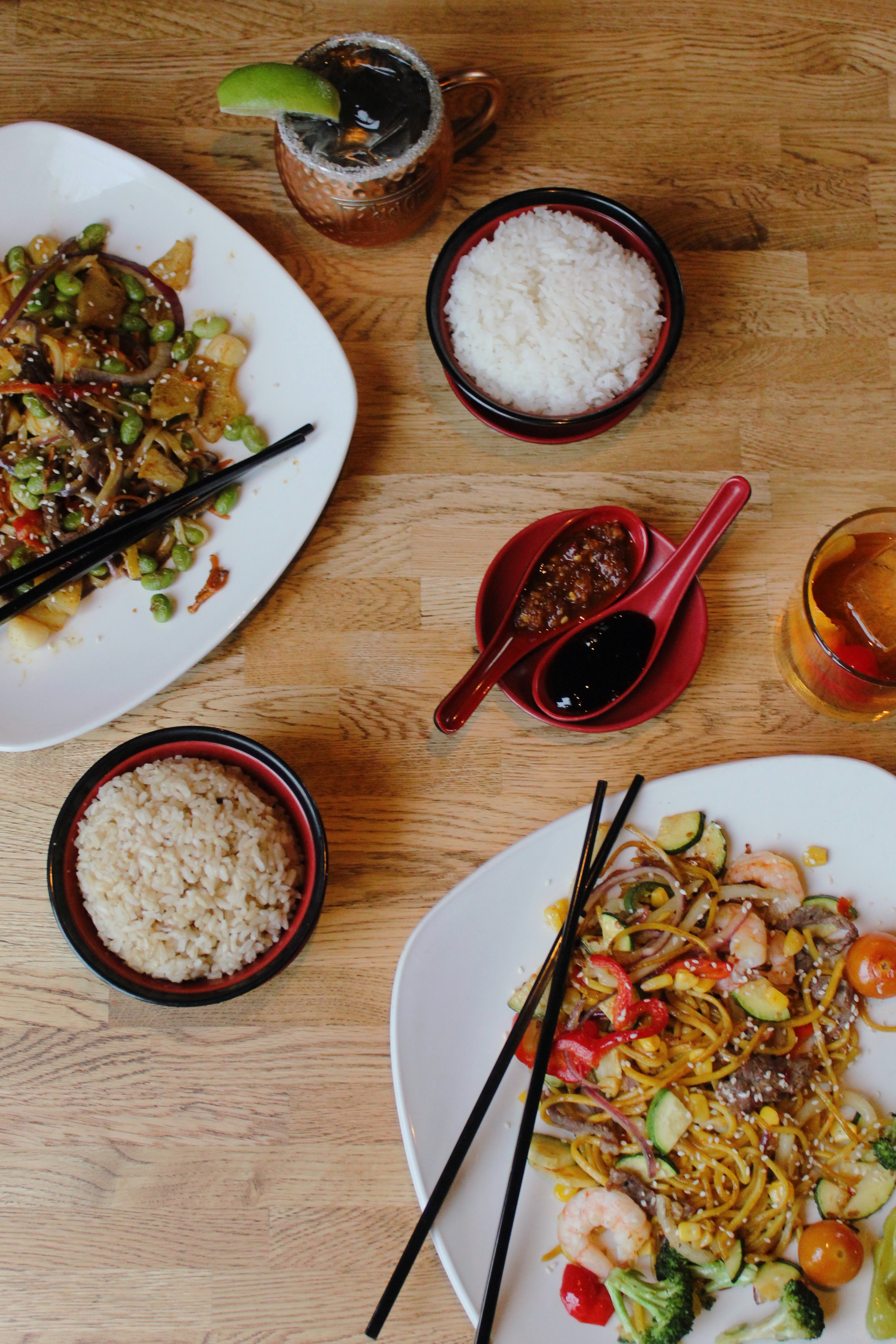Top-down view of plates, rice, sauces and cocktails